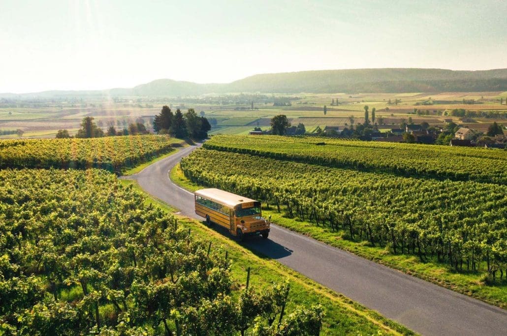 Bus jaune dans les vignes - Swiss Wine Tour lors d’une activité oenotouristique en Suisse